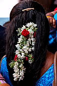 Scented garlands of fresh flowers swaying in women black hair near the Swamimalai temple. 